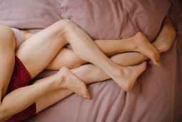 Nackte Beine im Bett im Sommer